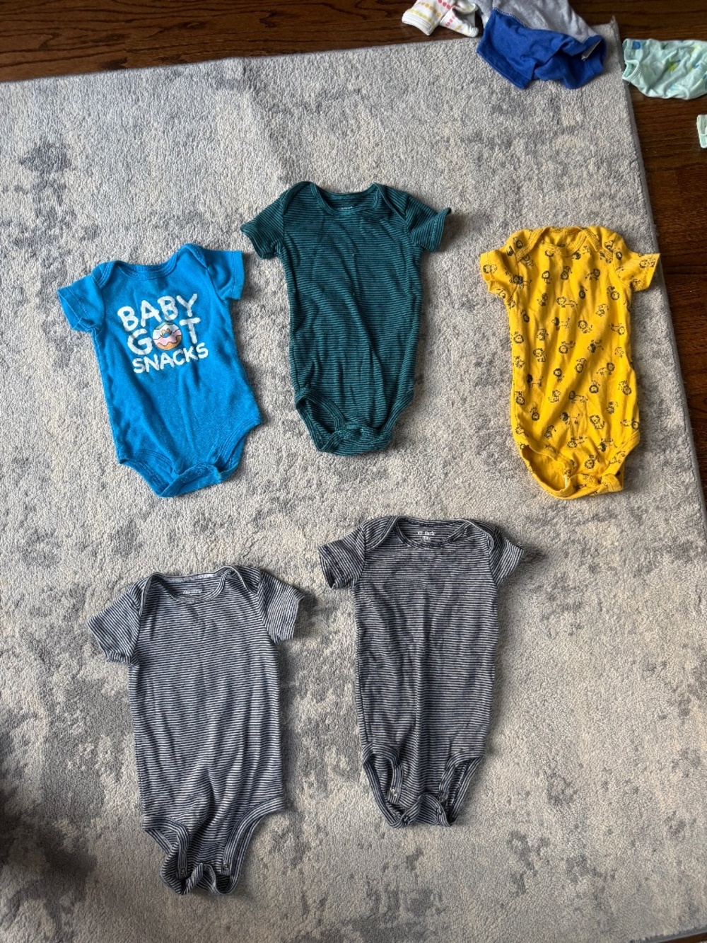 Lot of assorted Carters bodysuits and onesies between 6 and 9 months in size